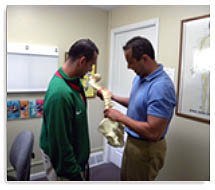 Dr Mark Augello talks to client about Chiropractic Care
